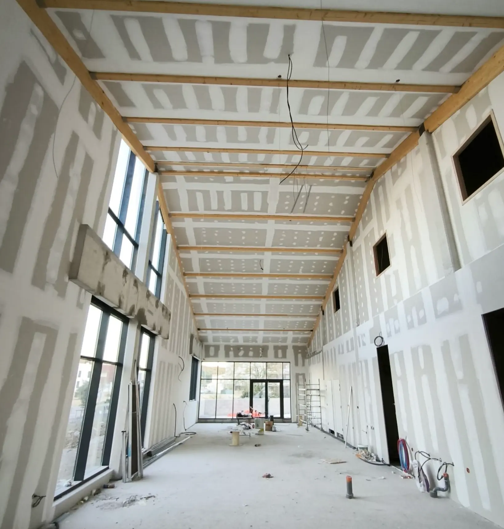 Doublage et plafond sous charpente d'un grand volume vitré, local professionnel